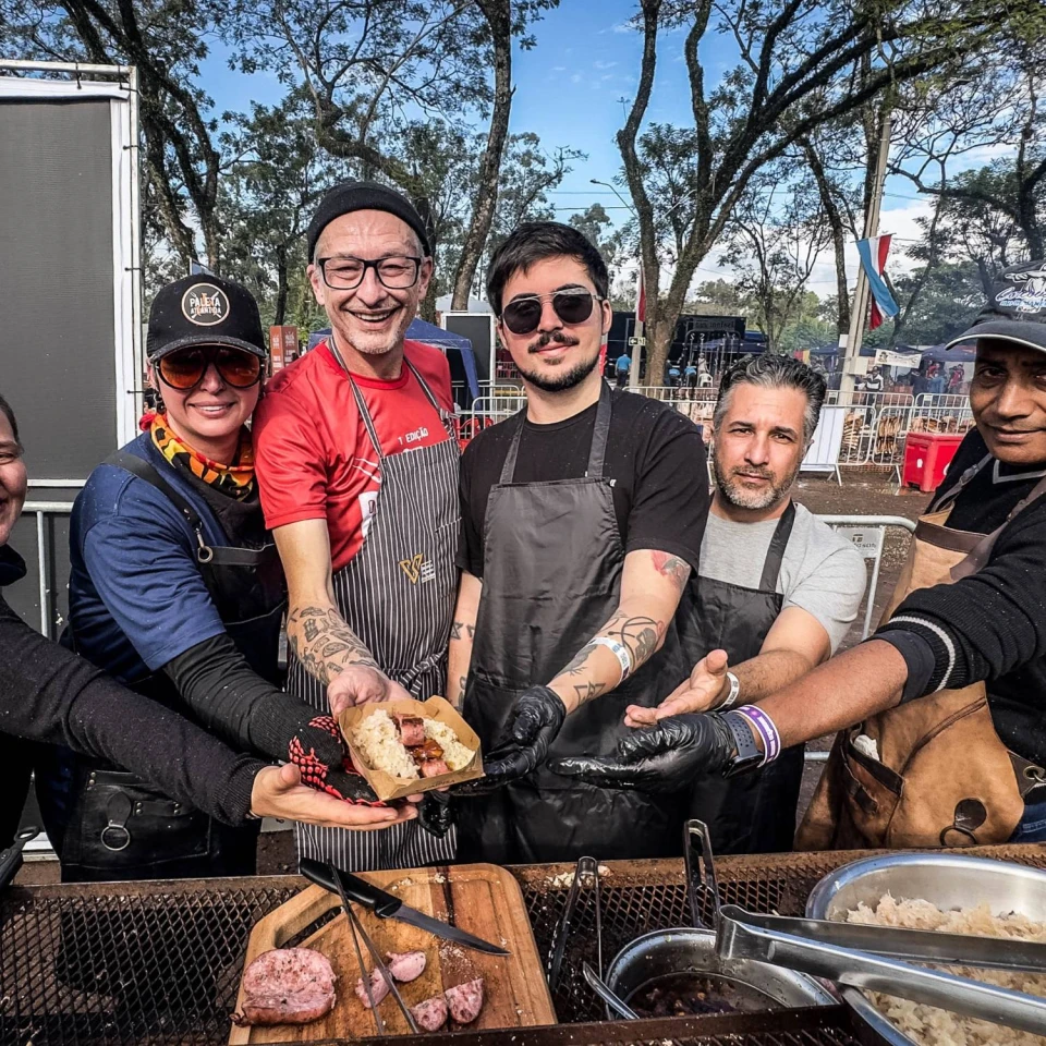 Equipe de assadores mostra uma porção de linguiça com chucrute no Paleta Atlântida Estrela 2026